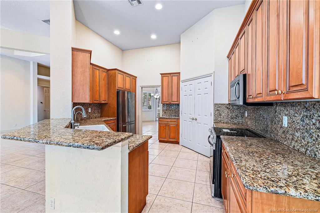 105 Henry Sewall Way Stuart, FL 34996 - Photo 13 of 33 a kitchen with stainless steel appliances granite countertop a stove sink and cabinets