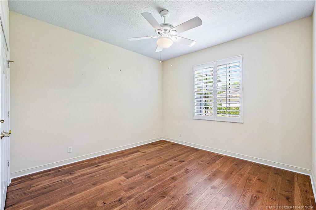 105 Henry Sewall Way Stuart, FL 34996 - Photo 18 of 33 an empty room with wooden floor and windows