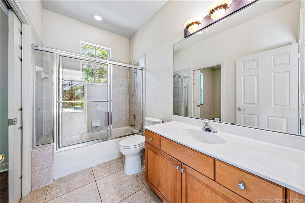 105 Henry Sewall Way Stuart, FL 34996 - Photo 23 of 33 a bathroom with a double vanity sink toilet mirror and bathtub