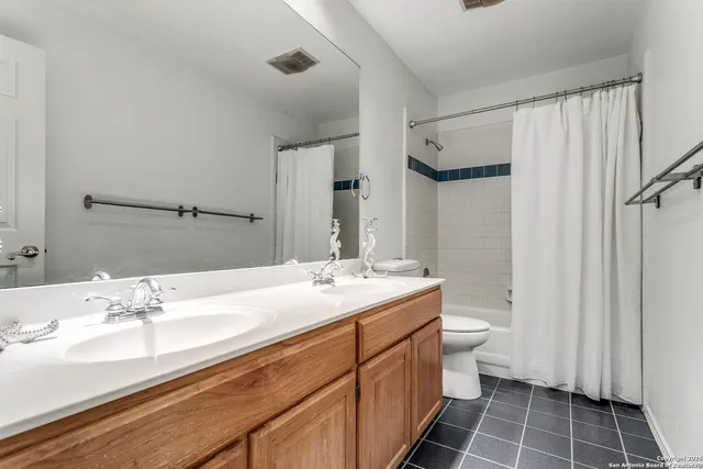 a bathroom with a double vanity sink mirror and toilet