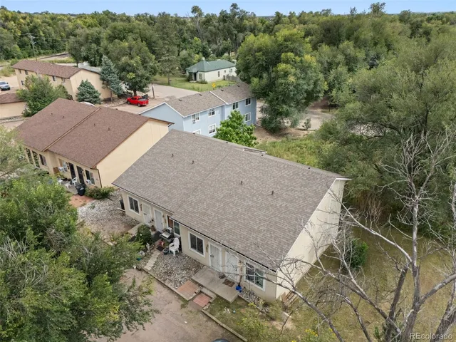 an aerial view of a house with yard and mountain in the background