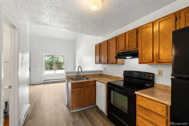 a kitchen with stainless steel appliances granite countertop wooden cabinets stove top oven and sink