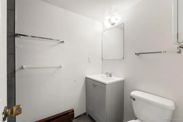 a bathroom with a toilet a sink and mirror