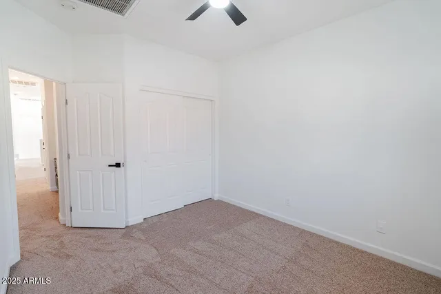 an empty room with chandelier fan
