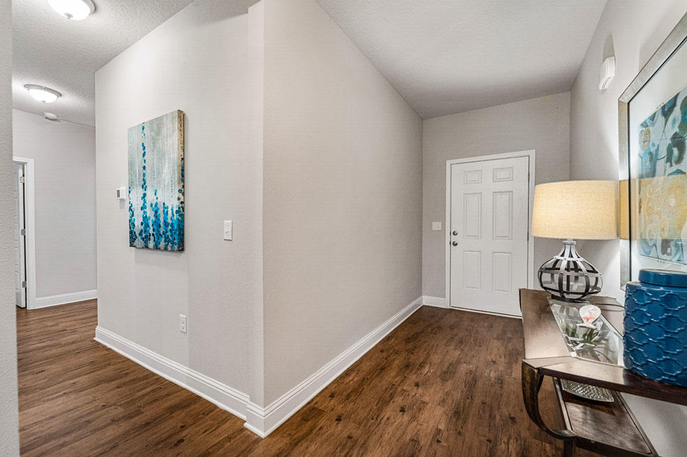 231 Conner Circle Santa Rosa Beach, FL 32459 - Photo 2 of 19 a view of a hallway to room with wooden floor and cabinet