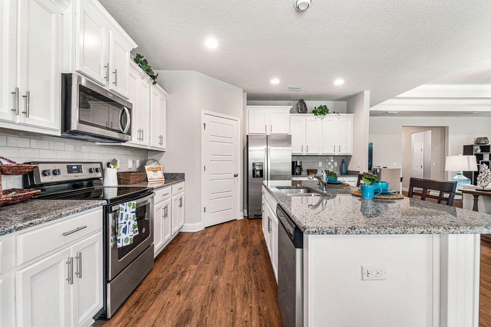 231 Conner Circle Santa Rosa Beach, FL 32459 - Photo 11 of 19 a kitchen with stainless steel appliances granite countertop a stove top oven a sink dishwasher and a refrigerator with wooden floor