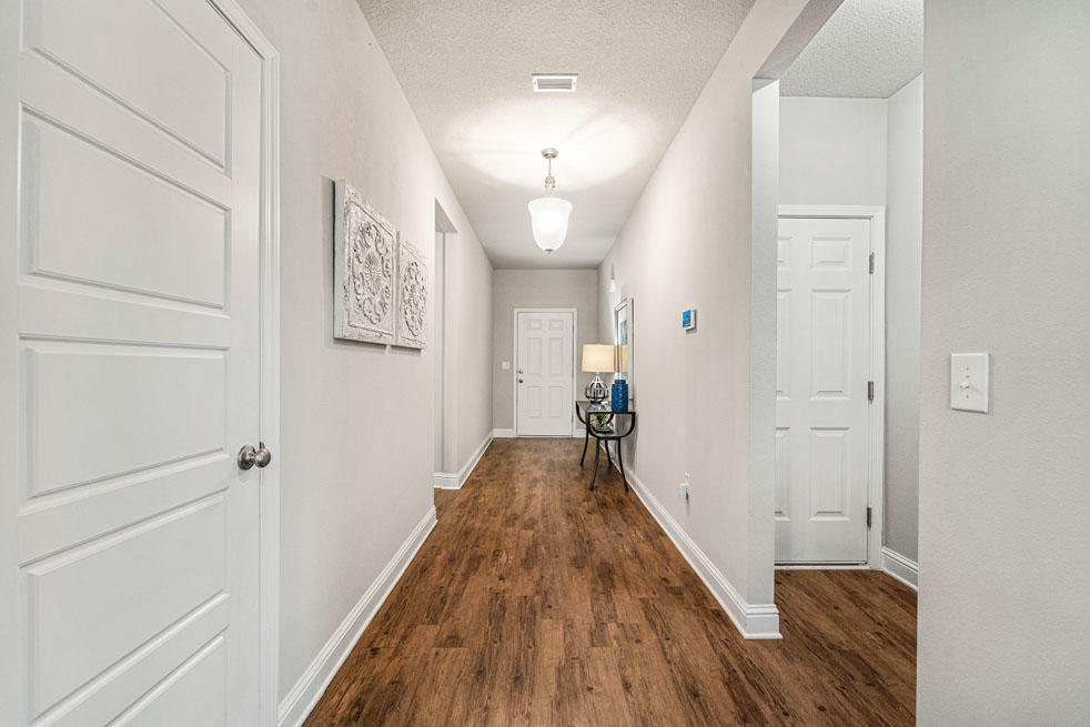 231 Conner Circle Santa Rosa Beach, FL 32459 - Photo 5 of 19 a view of a hallway with wooden floor and staircase