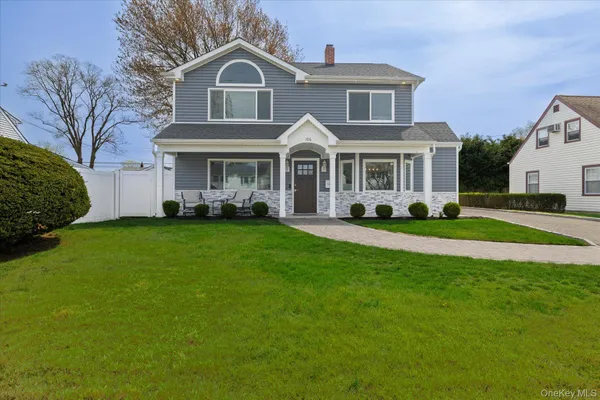 a front view of a house with a garden and trees