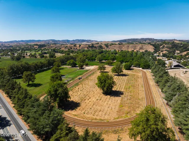 an aerial view of a house with a yard and lake view