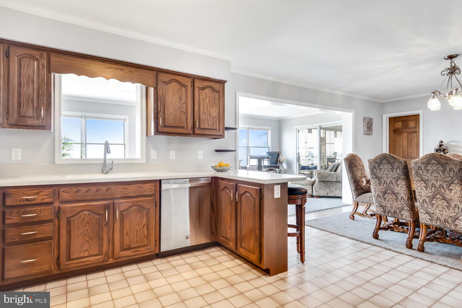 1015 Long Point Road Grasonville, MD 21638 - Photo 5 of 39 a kitchen with stainless steel appliances granite countertop a table chairs sink and cabinets