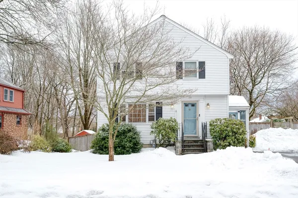 a view of a white house with a yard covered in snow