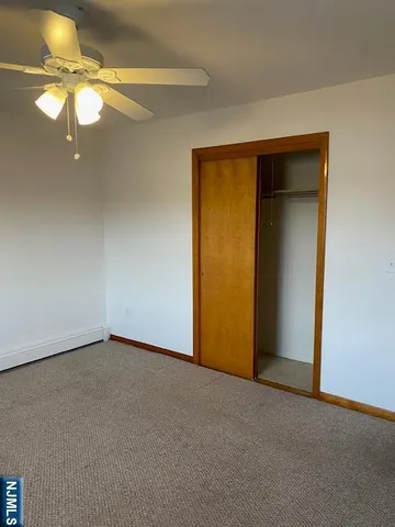 a view of an empty room with a chandelier fan