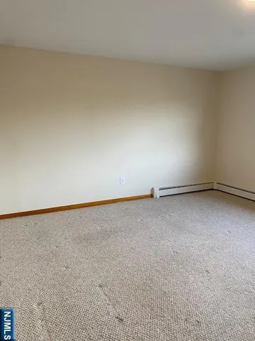 a view of an empty room and kitchen