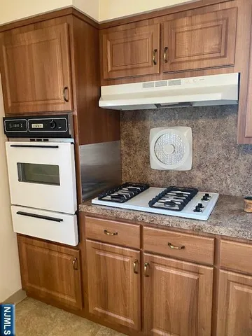 a stove top oven sitting inside of a kitchen