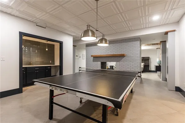 a living room with pool table a flat screen tv and a window