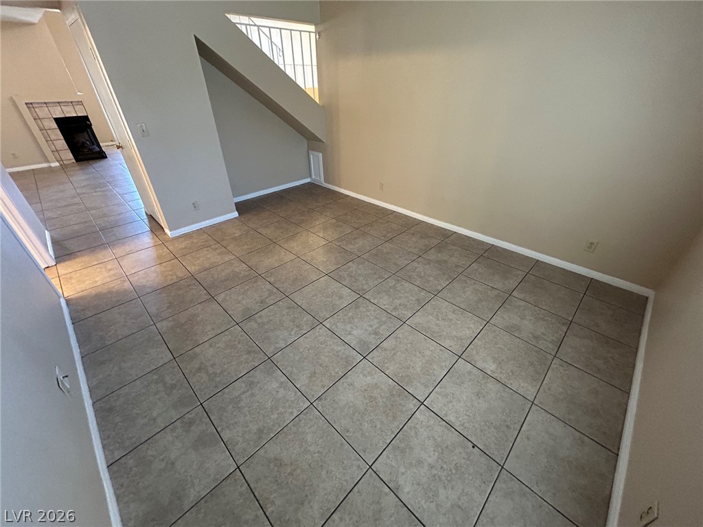 2806 Rungsted Street Las Vegas, NV 89142 - Photo 13 of 18 Functional tile flooring spans this versatile living space, extending towards a fireplace.