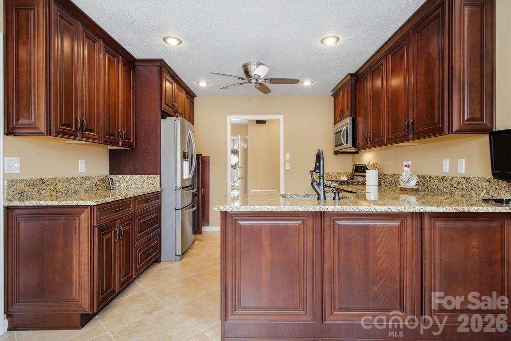 3100 Cove Loop Road Hendersonville, NC 28739 - Photo 16 of 43 a kitchen with stainless steel appliances granite countertop wooden cabinets a sink and dishwasher