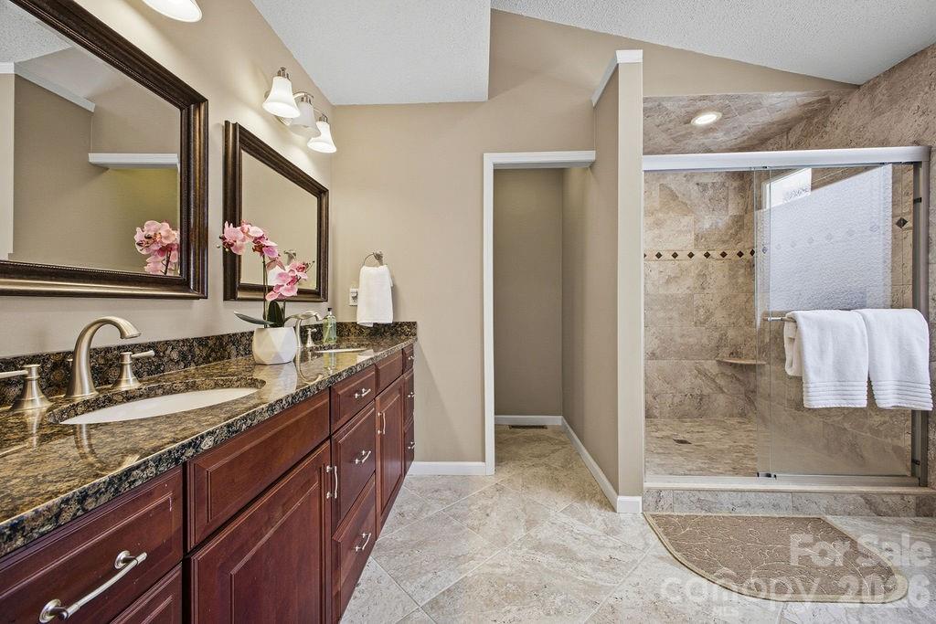 3100 Cove Loop Road Hendersonville, NC 28739 - Photo 23 of 43 a bathroom with a granite countertop tub sink and mirror