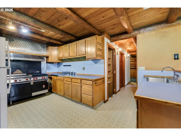 a kitchen with stainless steel appliances granite countertop a refrigerator a sink dishwasher a stove and a sink with dishwasher