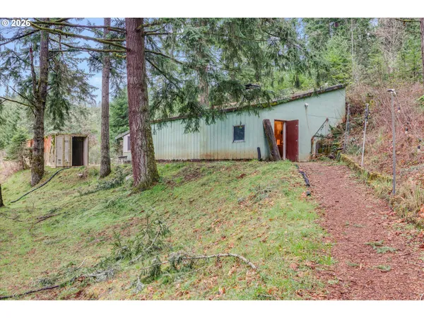 a kitchen view with stainless steel appliances wooden floor and living room view