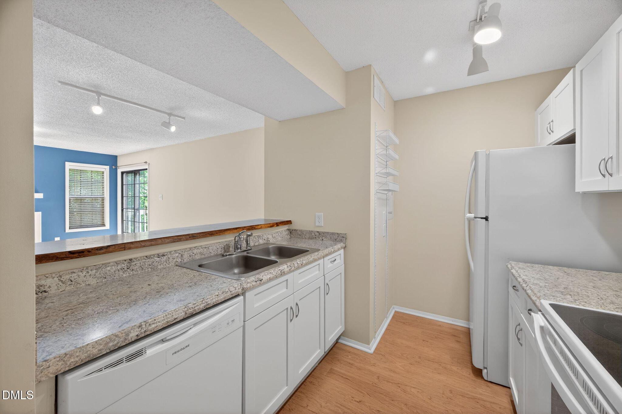 3704 Chimney Ridge Place, Unit 207 Durham, NC 27713 - Photo 4 of 31 a kitchen with a sink and a refrigerator
