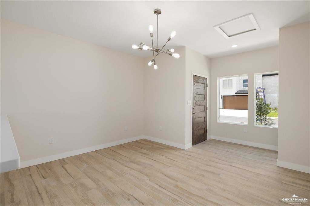 2508 East Solar Drive Mission, TX 78574 - Photo 2 of 13 an empty room with wooden floor chandelier fan and windows