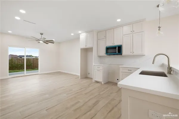 a view of a kitchen with a sink and dishwasher with wooden floor