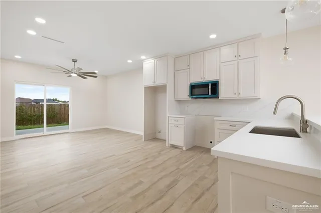 a view of a kitchen with a sink and dishwasher with wooden floor