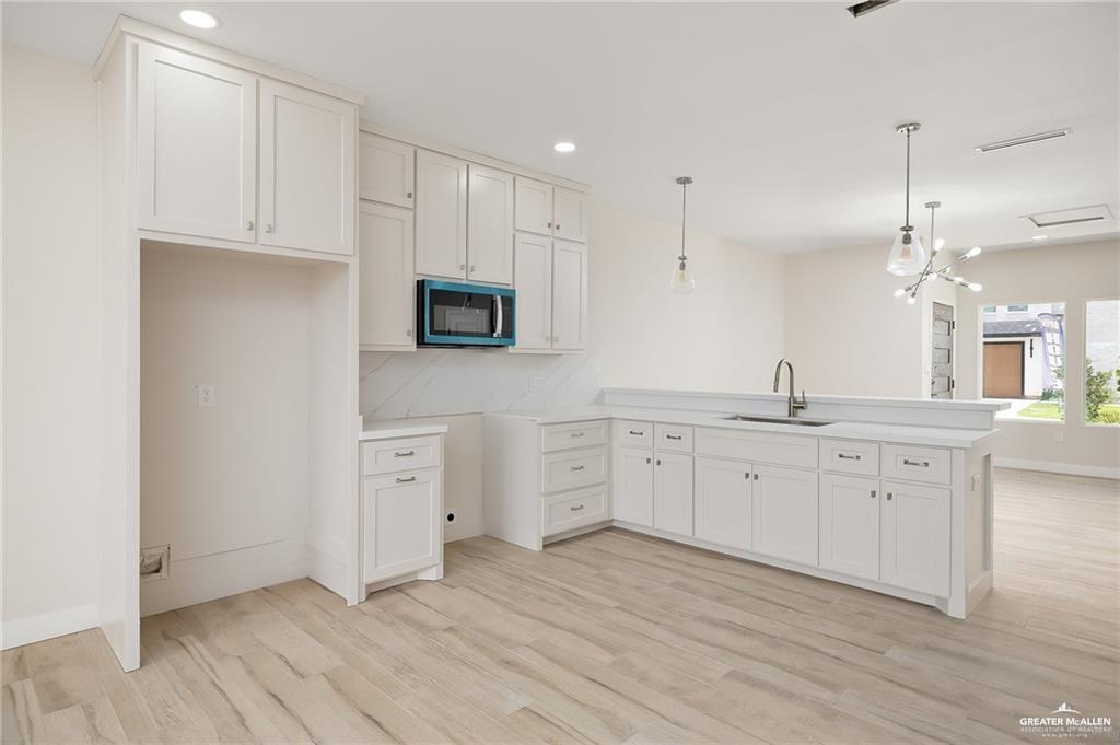 2508 East Solar Drive Mission, TX 78574 - Photo 5 of 13 a large kitchen with cabinets stainless steel appliances a sink and wooden floor