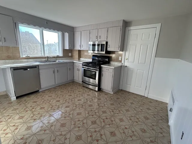 a kitchen with a stove a sink and a refrigerator
