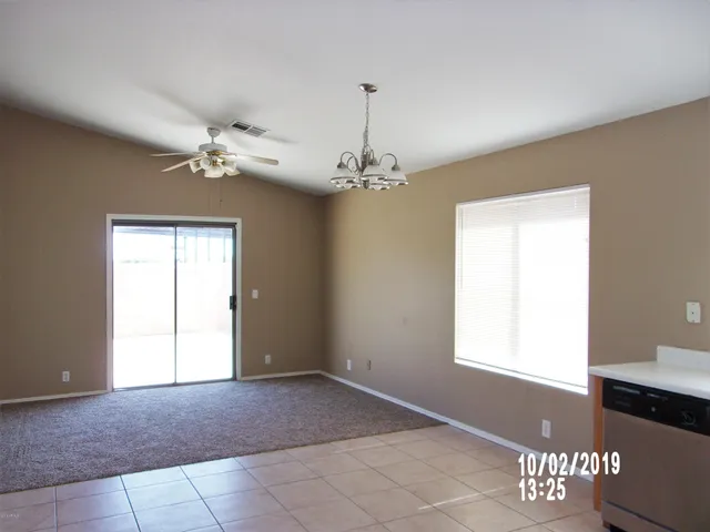 a view of a livingroom with a chandelier fan and a large window