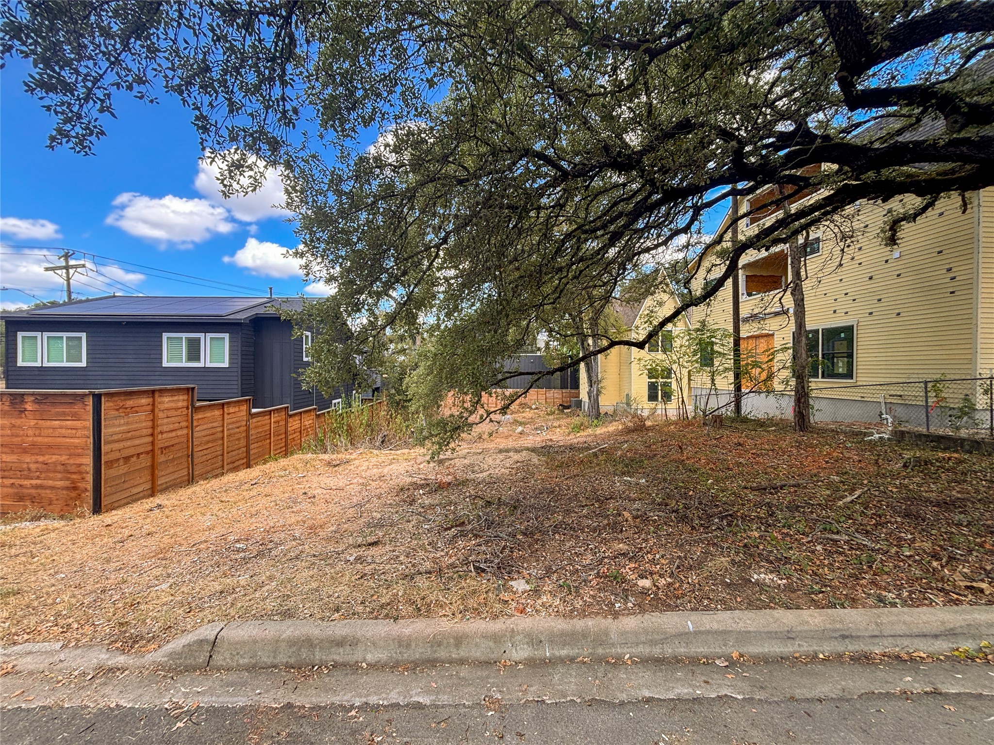 4602 Santa Anna Street Austin, TX 78721 - Photo 14 of 14 Mature trees shade a vacant residential building lot positioned between established homes.