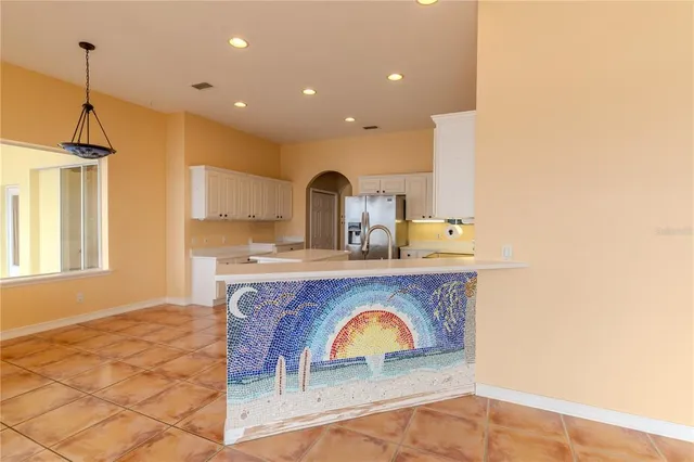 a kitchen with a sink a counter appliances and cabinets