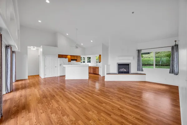 a view of a big room with wooden floor and a fireplace