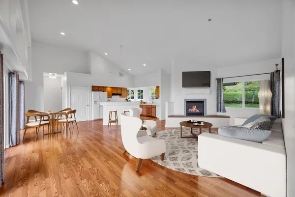 a living room with fireplace furniture and a large window