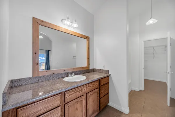 a bathroom with a granite countertop sink and a mirror