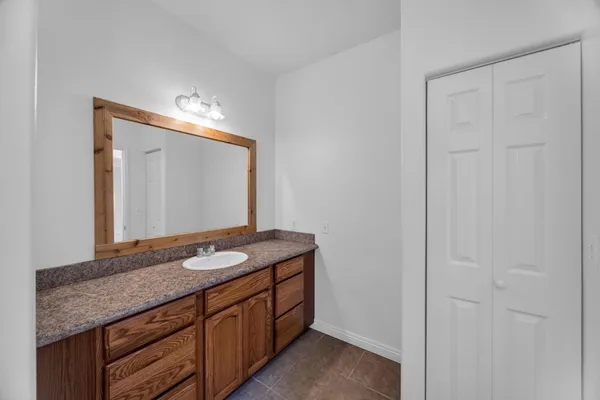 a bathroom with a granite countertop sink and a mirror