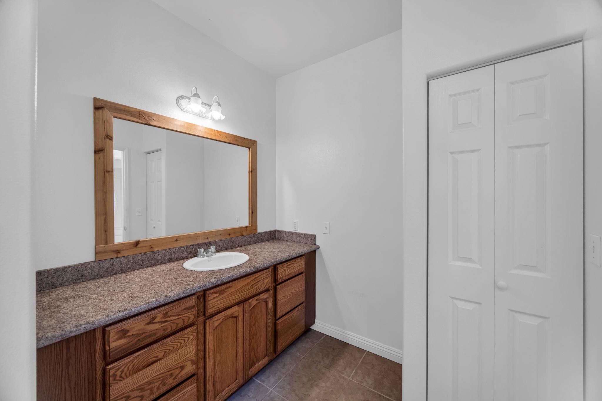 115 Alae Road Kula, HI 96790 - Photo 31 of 50 a bathroom with a granite countertop sink and a mirror