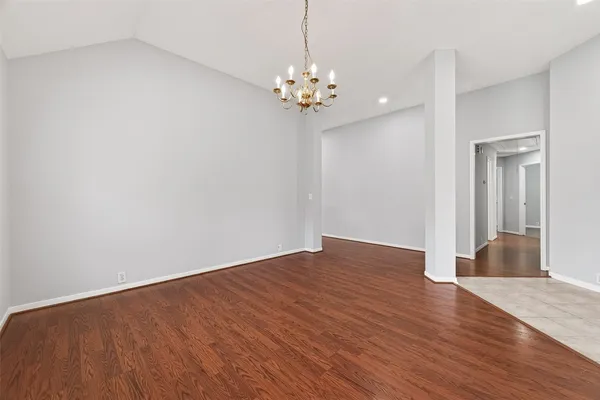 a view of a room with wooden floor and chandelier