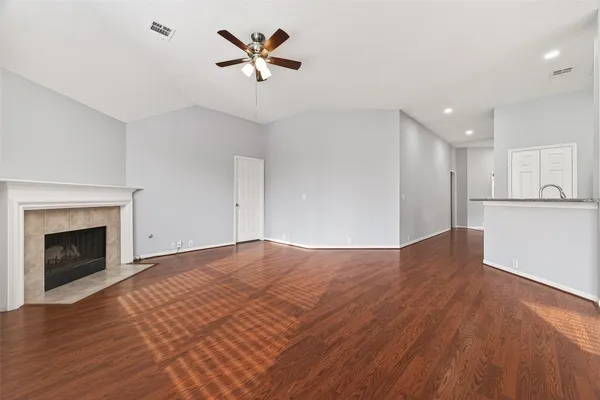 a view of empty room with wooden floor and fireplace