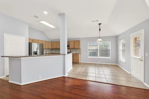 a view of a kitchen with wooden floor and a refrigerator