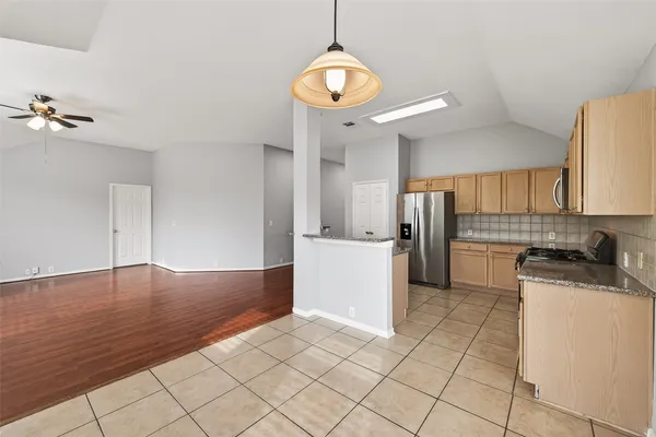 a kitchen with a refrigerator a stove top oven a sink and cabinets