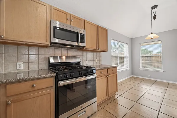 a kitchen with stainless steel appliances granite countertop a stove and a microwave