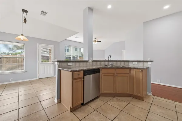 a kitchen with kitchen island granite countertop a sink a counter top space and cabinets