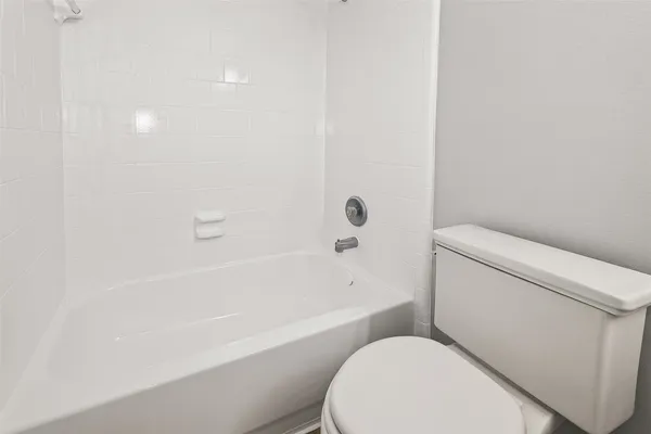 a white toilet sitting next to a bath tub