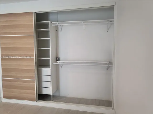 a view of walk in closet with empty racks
