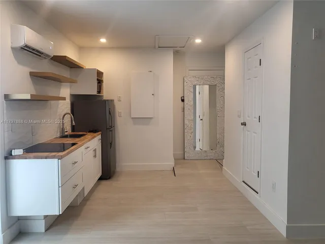 a kitchen with a sink a refrigerator and cabinets
