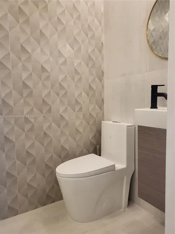 a white toilet sitting next to a shower