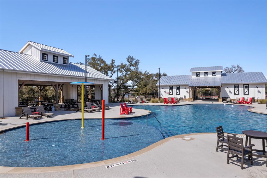 204 Swinging H Lane Georgetown, TX 78633 - Photo 3 of 39 Community swimming pool area featuring a large pool with shallow entry, surrounded by a paved deck with lounge chairs and tables