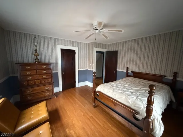 a bed sitting in a spacious bedroom and a dresser